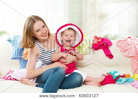 Happy  Mother And Baby Girl With Clothes Ready For Traveling On Vacation
