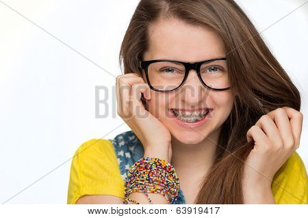 Cheerful girl with braces wearing geek glasses on white background