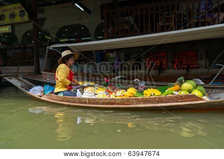 RATCHABURI, THAILAND - MARCH 24: Local peoples sell fruits, food and souvenirs at famous tourist attraction Damnoen Saduak floating market on March 24, 2014 in Ratchaburi, Thailand.