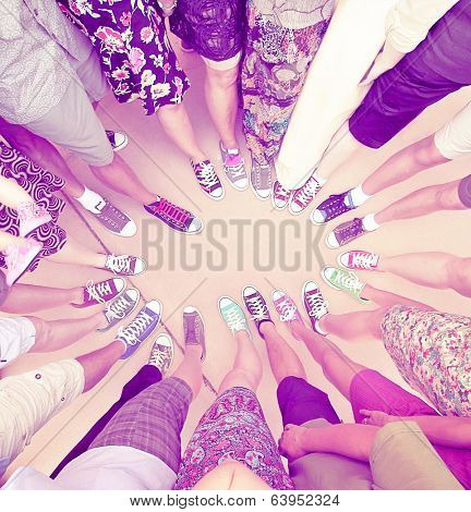 a group of friends with their legs in a complete circle done with a retro vintage instagram filter 