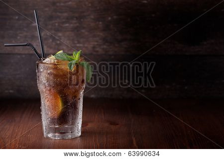 Cuba Libre Drink with lime on a wooden table