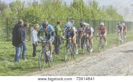 The Peloton On A Cobblestoned Road