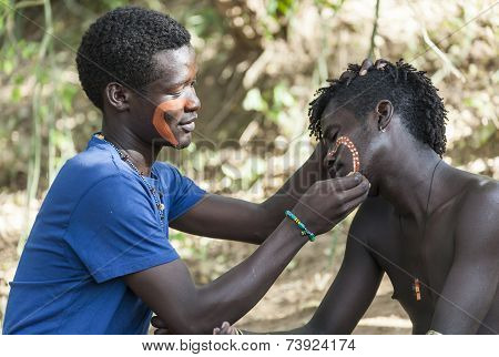 Hamar Men Paint Each Other's Face In A Preparation To A Bull Jumping Ceremony.