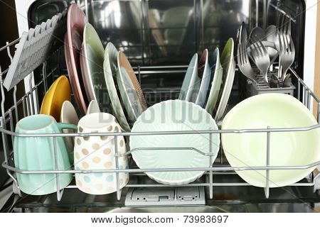 Open dishwasher with clean utensils in it