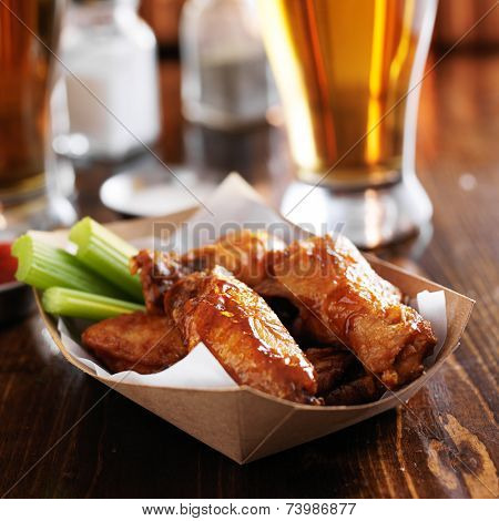 buffalo chicken wings in disposable tray with celery and ranch