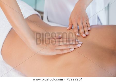 Close up mid section of a man receiving back massage at spa center