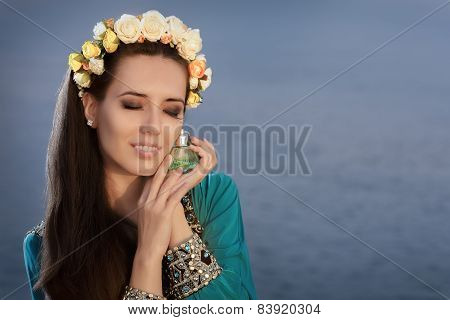 Young Woman With Floral Wreath Holding Perfume Bottle in Seaside Landscape