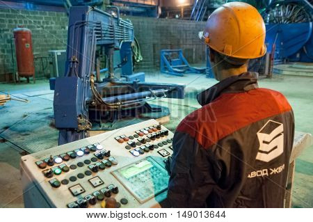 Tyumen, Russia - August 13, 2013: Circle pit making department at construction material factory ZHBI-5. Concrete Goods Plant No. 5. Worker control process of making circle concrete block