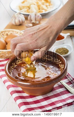 Chef Cracking An Egg On A Garlic Soup