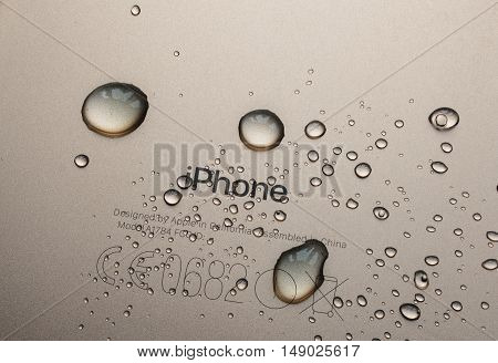 PARIS FRANCE - SEP 26 2016: New Apple iPhone 7 Plus unboxing and testing - iPhone engraved logo covered with rain drops. New iPhone7 is one of the best waterproof smart phone in the world