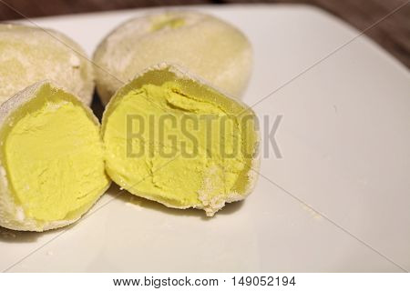 Green tea mochi ice cream bonbon desert on a white plate