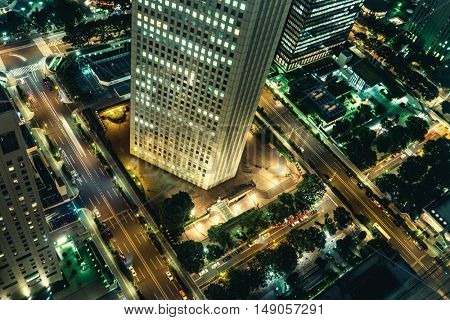 Tokyo - Aerial night view with office building and glowing light trails from traffic. Shinjuku. May 2016