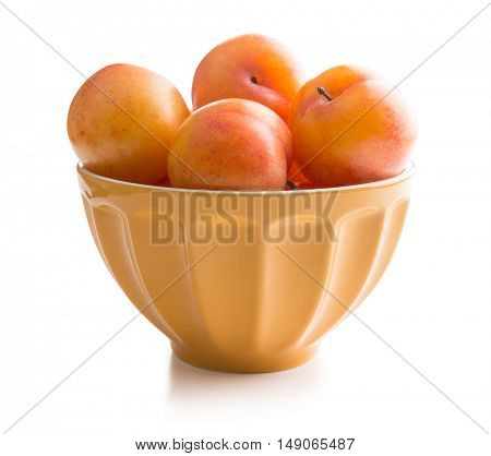 Ripe yellow plums in bowl isolated on white background.