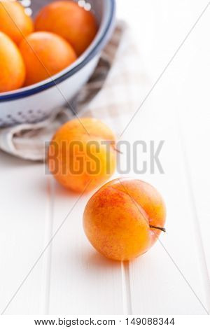 Ripe yellow plums on kitchen table.
