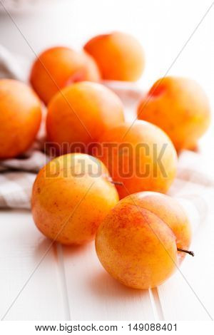Ripe yellow plums on kitchen table.