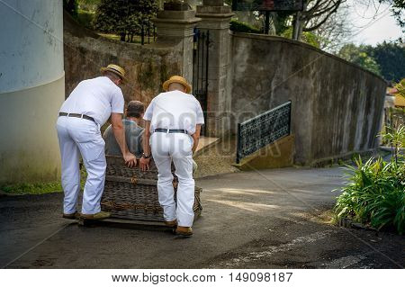 Traditional downhill sledge trip in Monte park. Sledges were used as local transport. Currently these Toboggan riders are a touristic attraction. Funchal, Madeira, Portugal