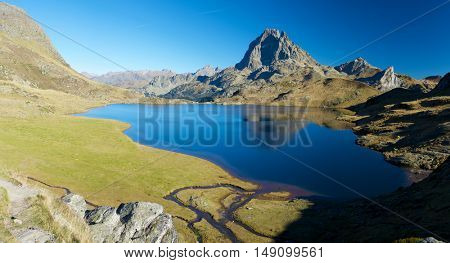 Midi Dossau Peak reflected in Gentau lake. Ossau Valley, Pyrenees National Park, Pyrenees, France.