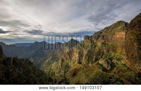 Backlit mountains in the Pico Arieiro to Pico Ruivo hiking route. Evening sun and cloudy skies. Madeira island, Portugal.