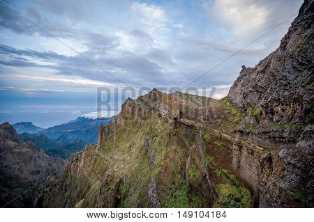 Evening light and hiking path on the edge of rocky cliff. Pico Arieiro, Madeira island, Portugal.