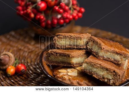 Fresh Dutch filled spicy cookies with almonds on autumn colored and dark background