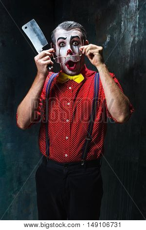The crazy clown holding a knife on dack. Halloween concept of horror and murderer