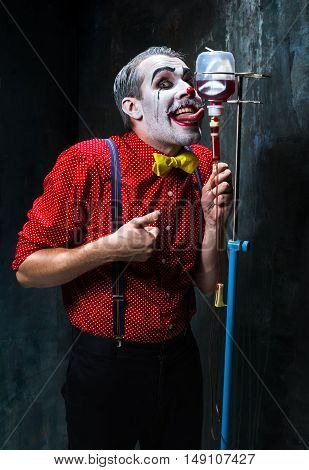 The scary clown and drip with blood on dack. Halloween concept of horror and murderer