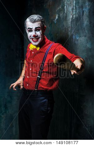 The scary clown and baseball-bat on dack. Halloween concept of horror and murderer