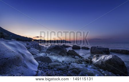 blue purple sunset on beach. Rocks on sea. Long exposure. magic nature landscape