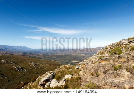 Green Valley Surrounded By Mountains With Clouds