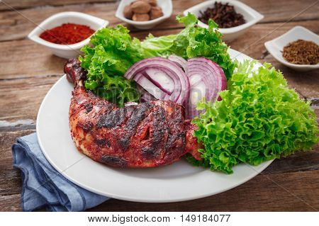 Indian tandoori leg chicken with spices and vegetables