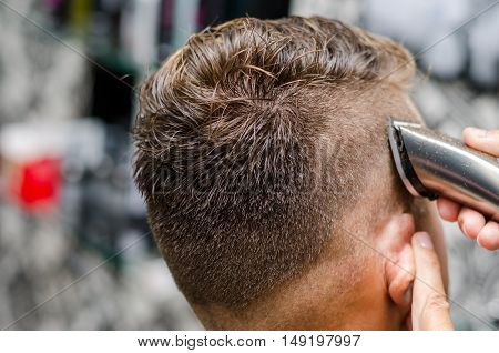 Barber cutting and modeling hair by electric trimmer