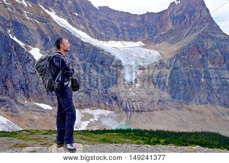 Man Hiker with Angel Glacier and lake view. Edith Cavell Meadows. Alberta. Canada.