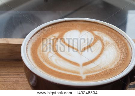 hot milk art coffee on wooden plate