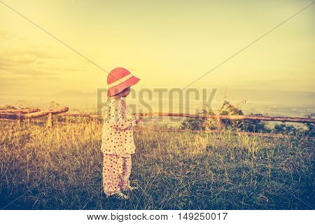 Asian Child Relaxing Outdoors, Travel On Vacation. Vintage Tone Effect.