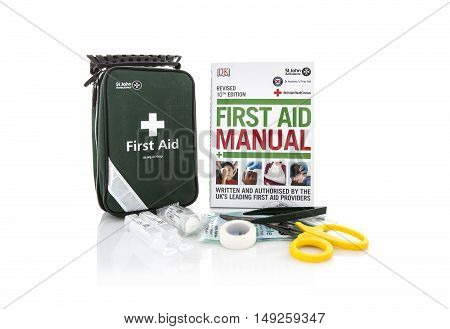 SWINDON UK - SEPTEMBER 25 2016: St John Ambulance First Aid Kit and Manual on a white background