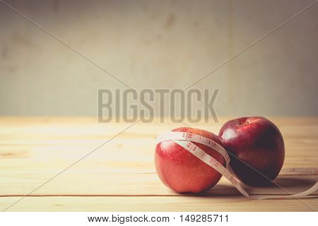 apples with measuring tape on wooden background vintage tone
