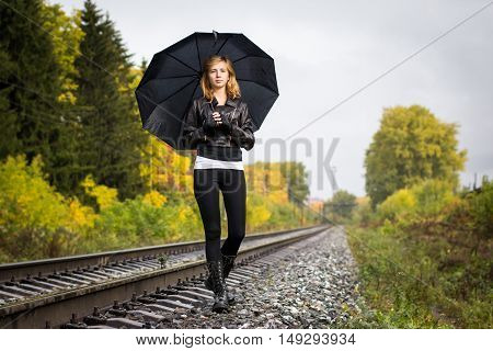 Girl, Umbrella And Rails In Autumn Day