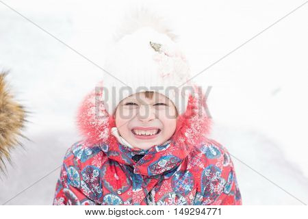 Closeup Portrait Of Gerl In Winter Clothes Outside Playing In The Snow Drifts In The Winter - Russia
