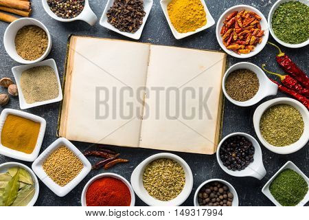 Blank cookbook and variuos spices and herbs. Top view.