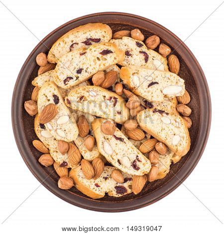Cookies with raisins and nuts in a ceramic plate. Isolated on white background. Top view.