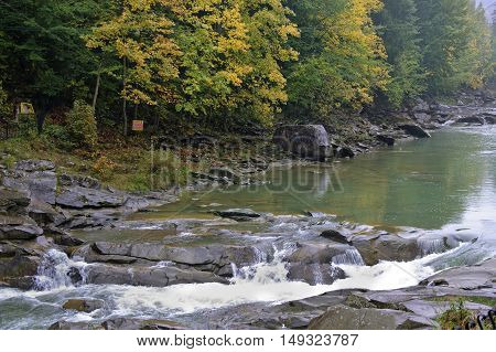 The bank of the Prut river in Carpathians at cloudy autumn day