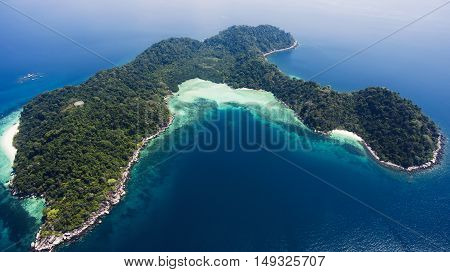 Aerial photo from flying drone of green island with tropical plants in open sea in summer sunny day in Thailand. Beautiful landscape of nature with Indian Ocean. Perfect background for travel website
