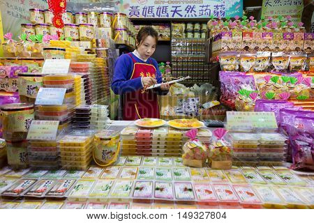 JIUFEN TAIWAN - 23 February 2016 - Female candy shop seller checks her goods in Jiufen Taiwan on February 23 2016