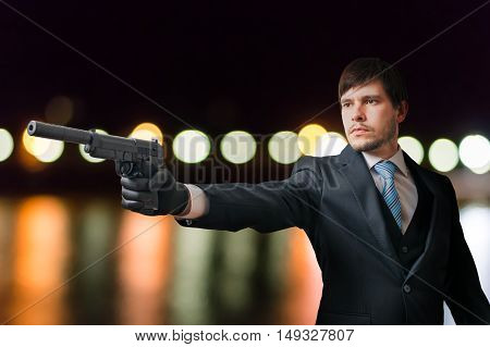 Agent Or Hitman Is Aiming With Pistol With Silencer At Night.