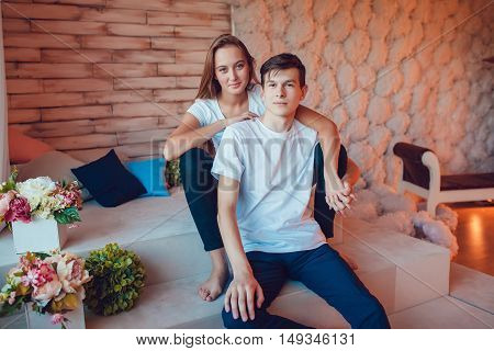 Young couple in love sitting embracing at home