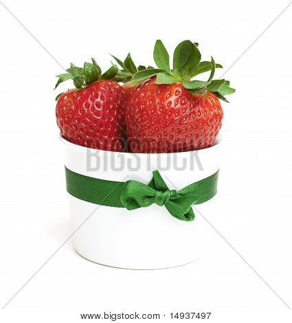 fresh strawberries in a white dish tied with a ribbon