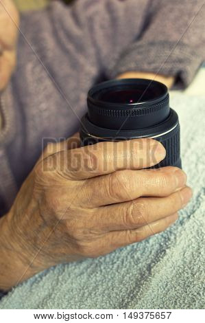 Old Hand holdind camera dslr lens on table