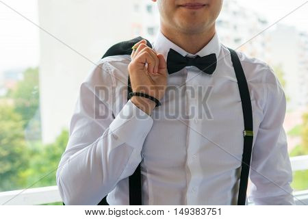 Fashion detail of groom wearing bowtie. Final preparations for wedding.