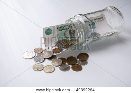 A thousand rubles and fines sticking out of a glass jar lying