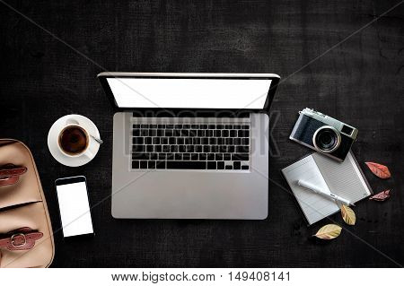 Top view of Work space on dark wood table of a creative designer or photographer.